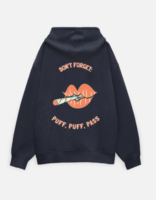 Navy oversized hoodie with a large back graphic of peach lips holding a rolled cig, with curved text reading “DON’T FORGET:” above and “PUFF, PUFF, PASS” below.