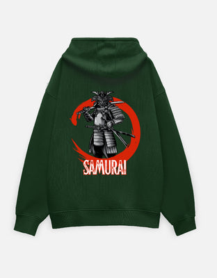 Dark green oversized hoodie with a large back graphic of a monochrome samurai framed by a red brush-circle and the word “SAMURAI” below.