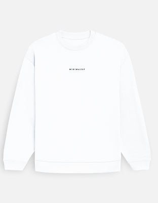 Oversized white sweatshirt with small center-chest “MINIMALIST” wordmark embroidered in black.