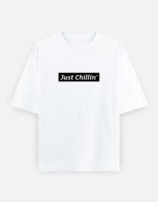 Oversized t-shirt with bold white “Just Chillin’” typography across the chest on a black backdrop — minimal, clean, and relaxed streetwear style.