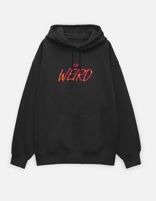 Black oversized hoodie with neon-style text “STAY WEIRD” printed in red and yellow gradient on the front center.