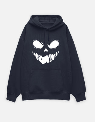Black oversized hoodie with a bold white graphic of a sinister grin face featuring hollow eyes and jagged teeth on the front.