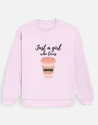 Oversized pastel pink sweatshirt with front-center script text reading “Just a girl who loves” above a pastel coffee cup labeled “COFFEE.”