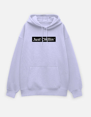 Oversized light grey hoodie with a black box-logo reading “Just Chillin’” on the front center.