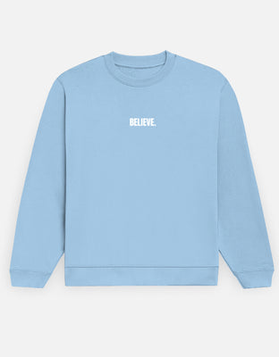Oversized sky blue sweatshirt with small center-chest embroidered white text reading “BELIEVE.”